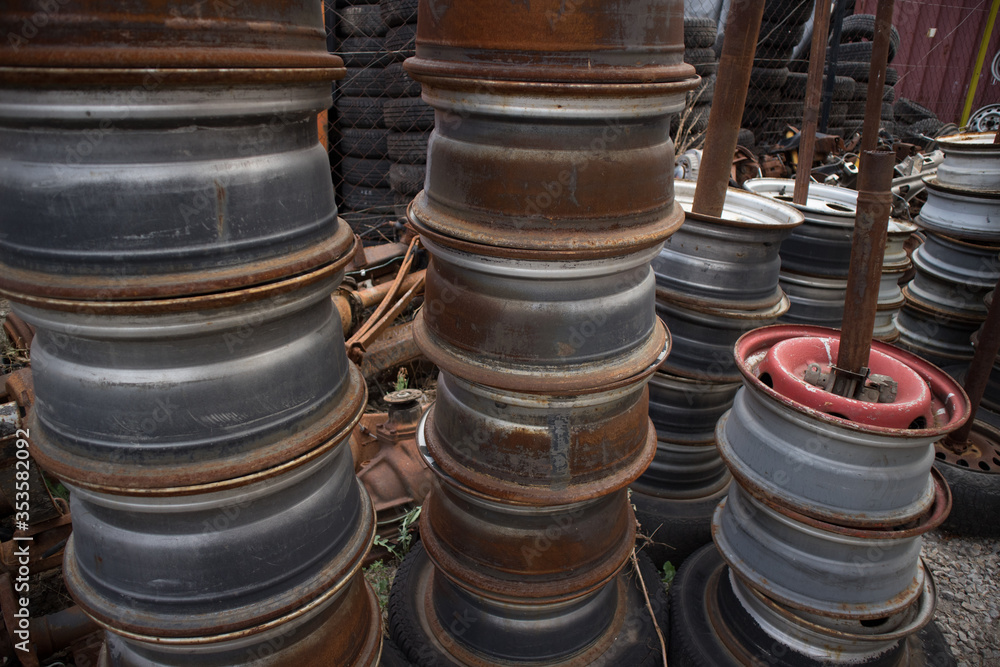 Used rims at columns, in a nice order. Awaiting recycling or re-sale. At a car cemetery, Kozani, Greece. Used rims at columns, in a nice order. Awaiting recycling or re-sale. At a car cemetery, Kozani, Greece.