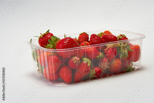 Tray of ripe red strawberries on a white background.