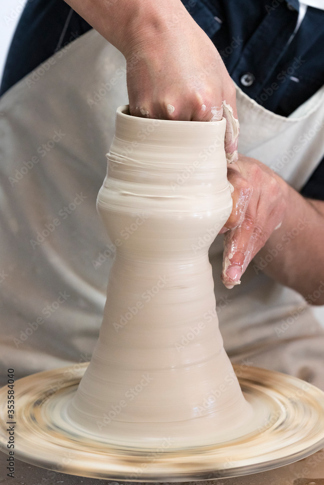Potter sculpts from clay in a workshop of pots using ancient technology. Potter sculpts from clay in a workshop of pots using ancient technology.