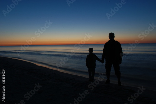 child with a parent on the beach