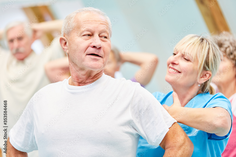 Senior in back exercises with trainer