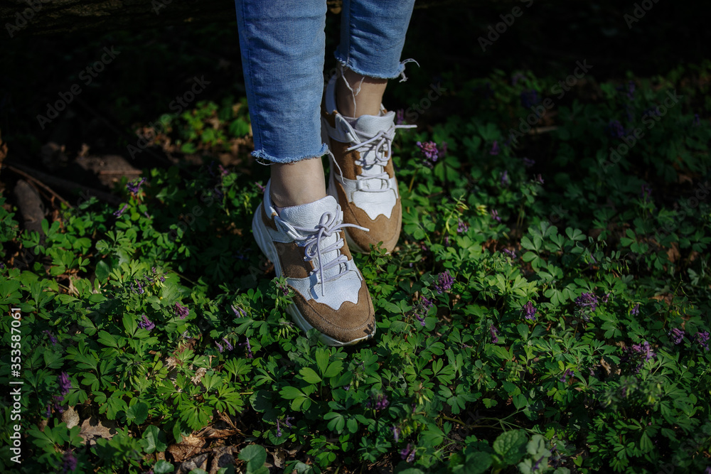 legs of a girl on a background of beautiful greenery legs of a girl on a background of beautiful greenery