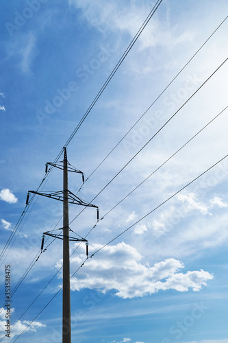 high-voltage electric line against a bright beautiful sky