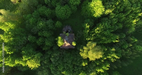 4K high quality early summer sunny afternoon aerial video footage of abandoned village site with ruins of houses and church in the middle of dense green wild woods in Russia's Yaroslavl region