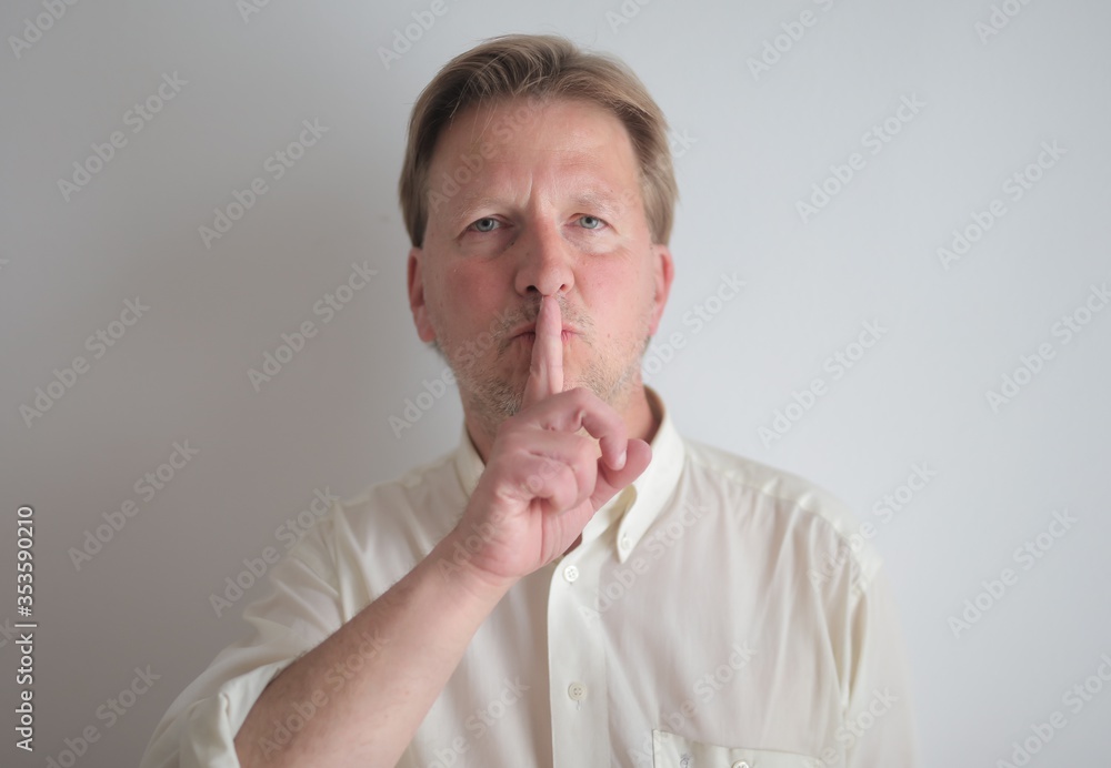 man indicates with hand to be silent
man indicates with hand to be silent
