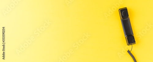 Vintage handset on yellow desktop with copyspace. Hotline concept. Banner