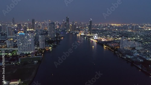 Wallpaper Mural Aerial shot of river amidst illuminated buildings in city, drone flying forward over cityscape at night against sky - Bangkok, Thailand Torontodigital.ca