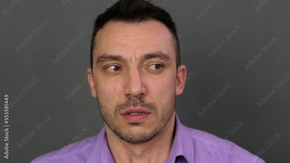 Fear on the face of a young man close-up. He shows emotions. Professional acting. Soft light. High-quality footage FullHD. Video 1920x1080.