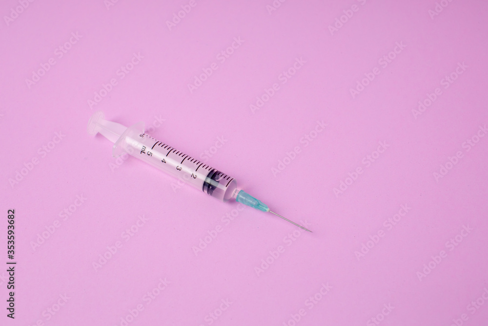 Small syringe placed on a pink background. hospital tools model for medicine Small syringe placed on a pink background. hospital tools model for medicine