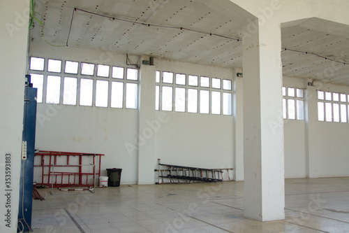 Foto Interior de una nave industrial con paredes blancas y ventanales