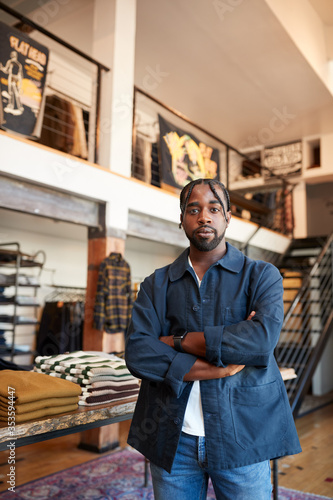 Portrait Of Male Owner Of Fashion Store Standing In Front Of Clothing Display