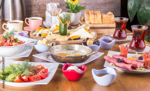 traditional van-turkish breakfast table : cheese plate, delicatessen plate, tomato-cucumber, olive, honey cream, bread