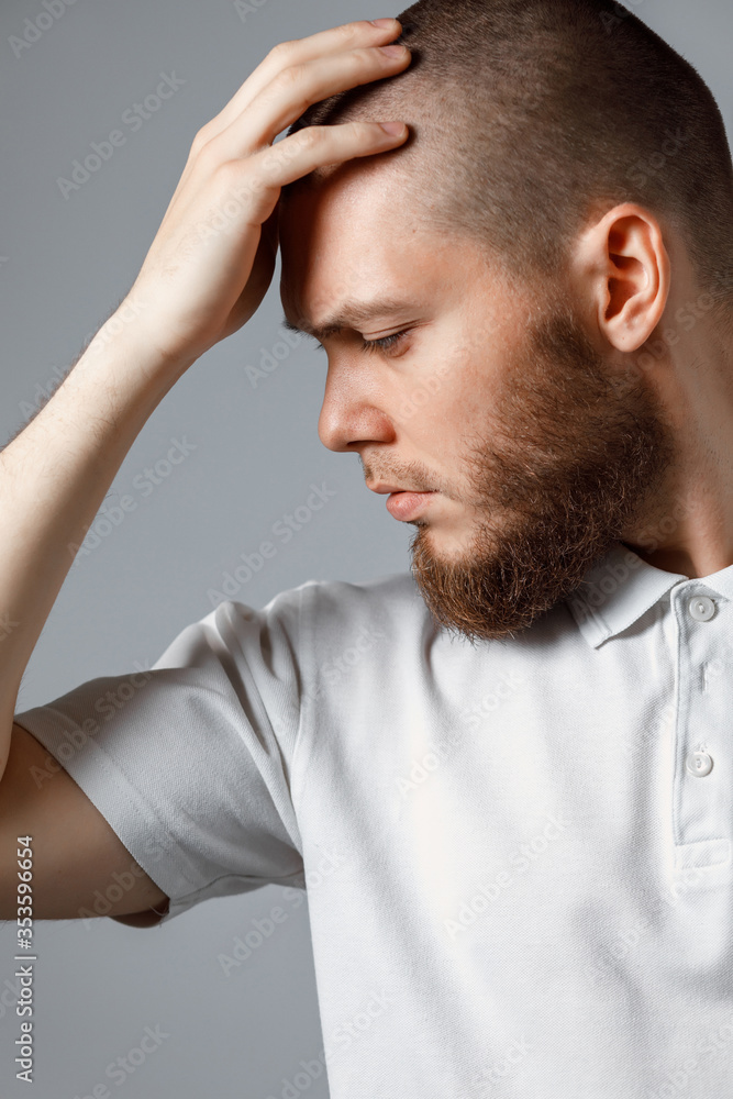 Portrait of a handsome young man looking upset to the side on gray background. isolated Portrait of a handsome young man looking upset to the side on gray background. isolated