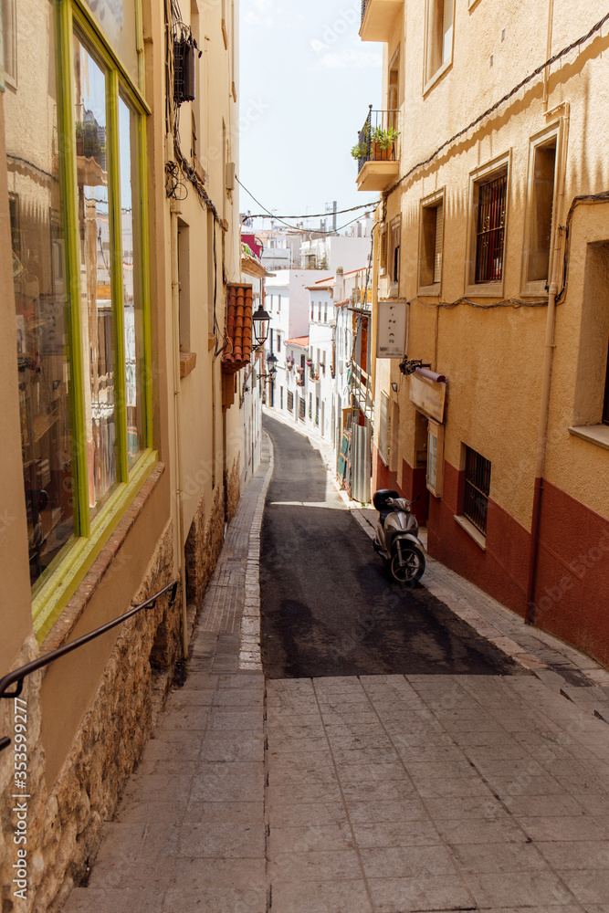Scooter near buildings on walkway of urban street in Catalonia, Spain