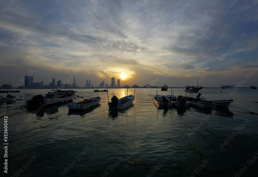 Bharain skyline and fishing boats during sunset.