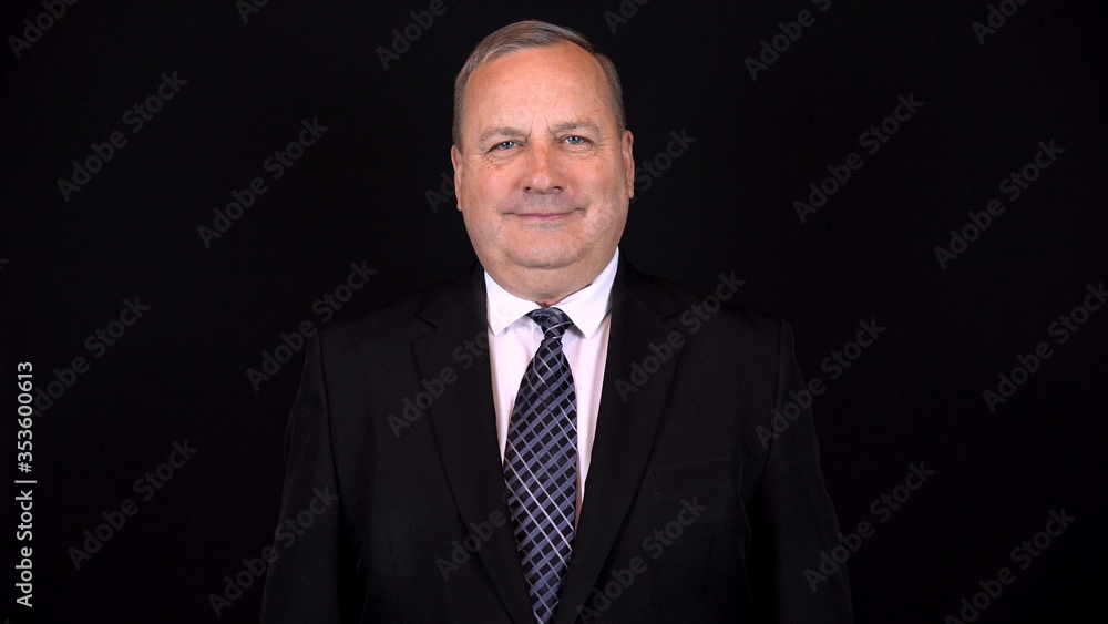 Old businessman in a suit smiling. Isolated black background. 4k Old businessman in a suit smiling. Isolated black background. 4k