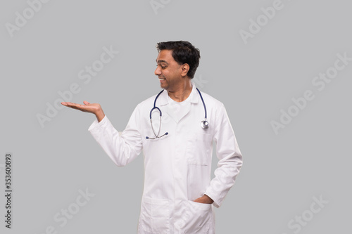 Doctor Holding Hand to Side Watching to Side Isolated. Indian Man Doctor Sign