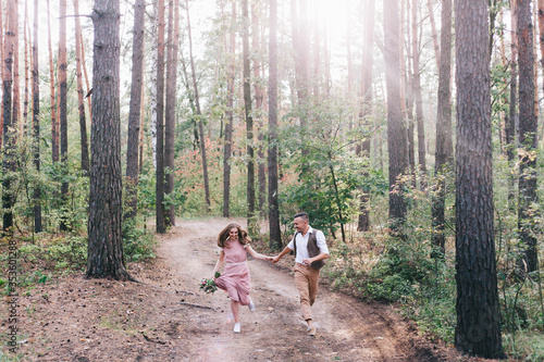 Beautiful couple at the photoshoot of love story in the forest in a rustic dress © Олег Блохин