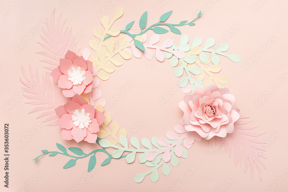 Flat lay of paper flowers on pastel pink background. Summer fashion and trendy frame