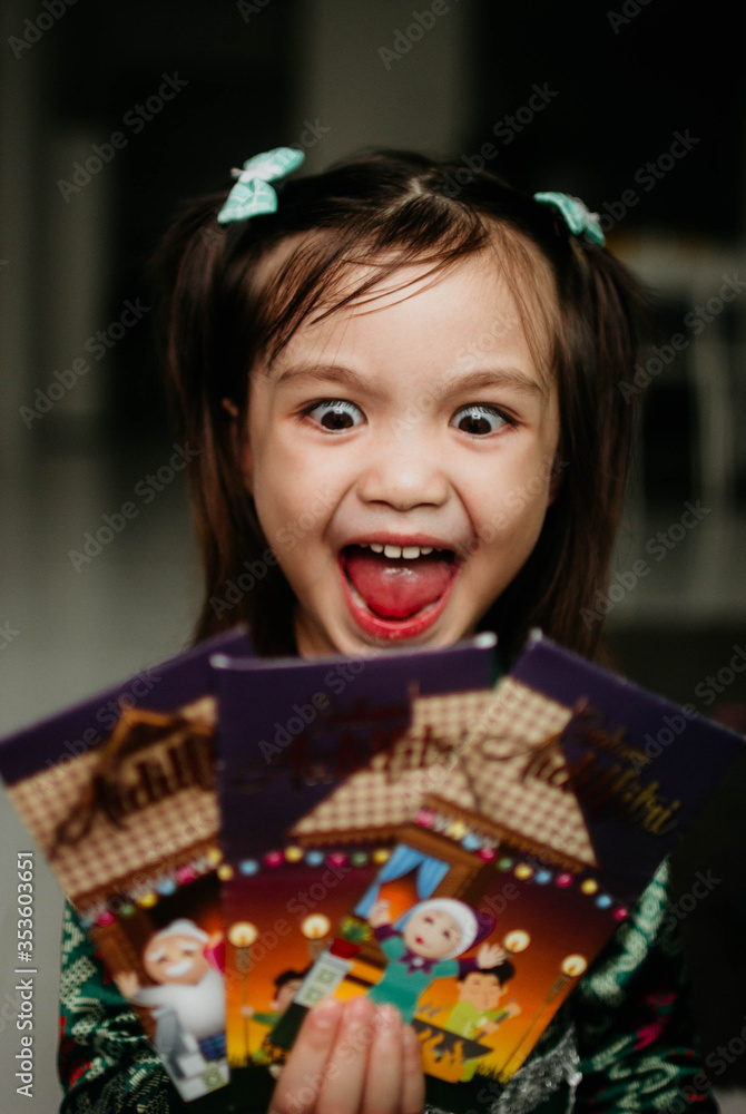 Little girl happy received money packets during festive season Hari Raya Puasa/Eid Mubarak