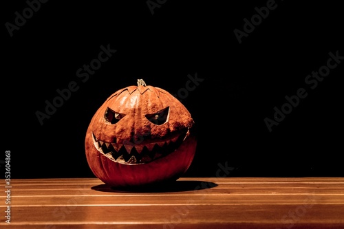 Lonely halloween pumpkin smile with black dark fire eyes mouth. Big spooky helloween symbol has darkest mad face and smiling with sharp teeth and bad look. Black orange nightmare of October 31st