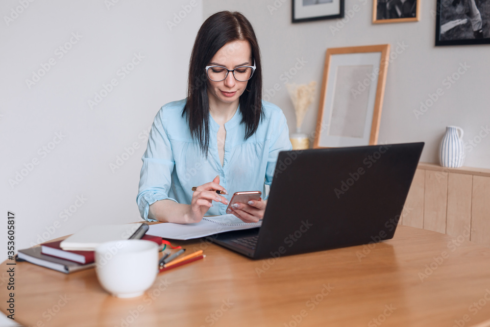 Businesswoman woman with computer and smartphone indoors, working in a home office. Businesswoman woman with computer and smartphone indoors, working in a home office.