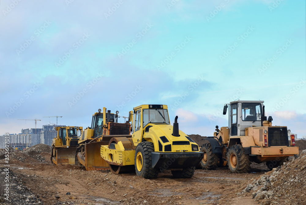 Soil Compactor, bulldozer and wheel loader during the construction of road at construction site. Heavy machinery for leveling the ground, land clearing, grading, pool excavation, trenching Soil Compactor, bulldozer and wheel loader during the construction of road at construction site. Heavy machinery for leveling the ground, land clearing, grading, pool excavation, trenching