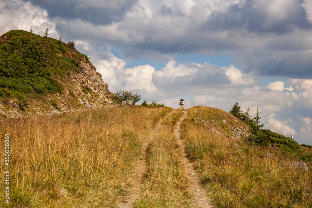 Hiker with backpack going uphill. Hiker going up to the mountain peak on a very steep trail. Hiker with backpack going uphill. Hiker going up to the mountain peak on a very steep trail.
