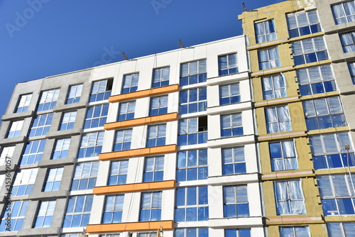 Construction of a new multi-storey building. Wall painting and insulation of the facade of the mineral wool. Modern residential building. Housing renovation program