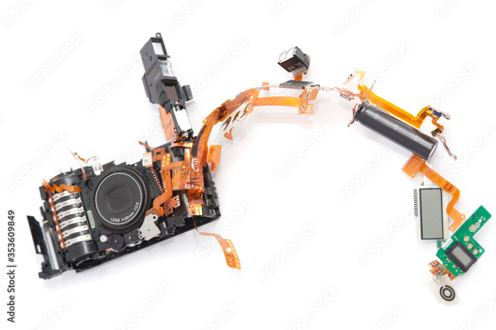 Dismantled camera lying in parts on white