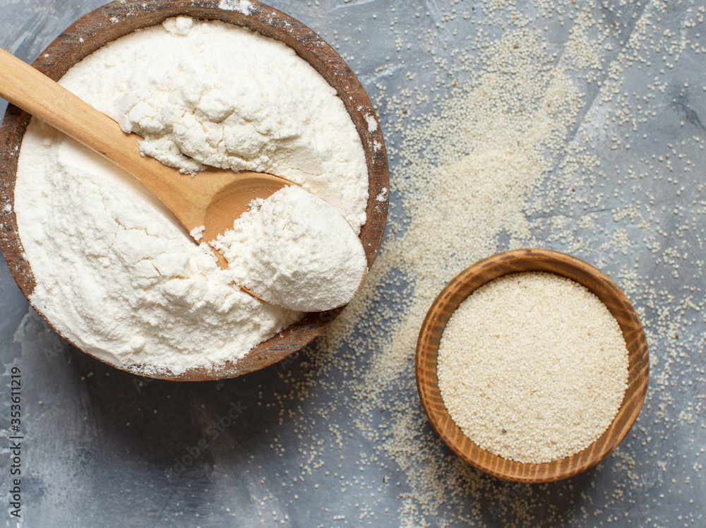 Raw fonio flour and seeds with a spoon on grey background Raw fonio flour and seeds with a spoon on grey background