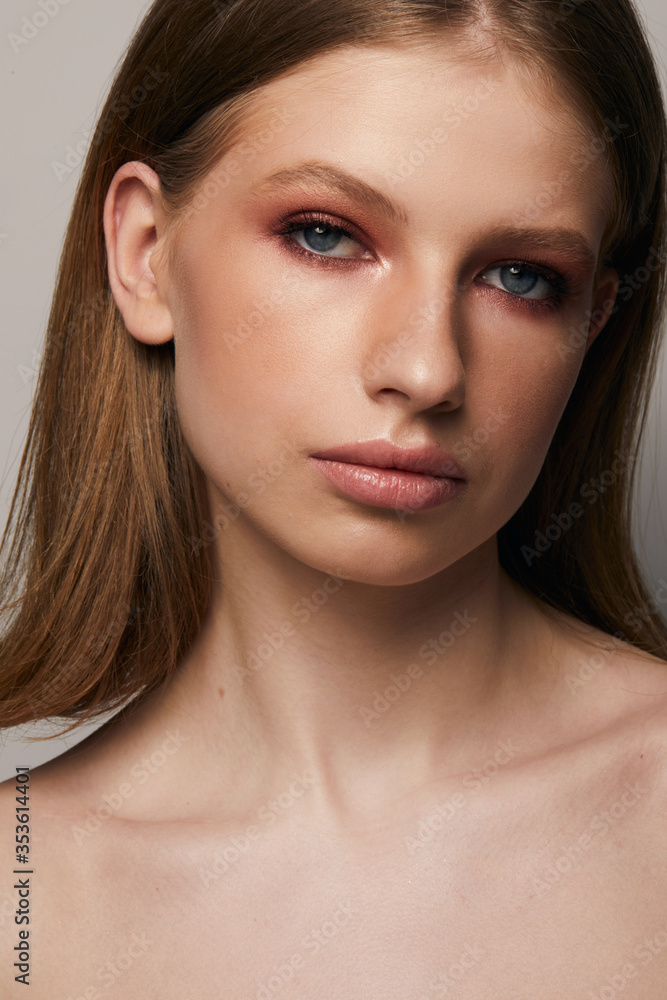 Beautiful face of young woman with clean fresh skin close up isolated on the grey background. Beauty portrait. Perfect fresh skin. Pure beauty model. Youth and skin care concept Beautiful face of young woman with clean fresh skin close up isolated on the grey background. Beauty portrait. Perfect fresh skin. Pure beauty model. Youth and skin care concept