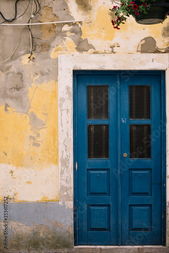 Beautiful blue door and old rustic yellow wall, close up view 