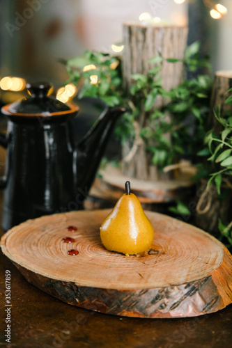 cake in the form of a pear on a wooden stump on the background of a teapot and cups