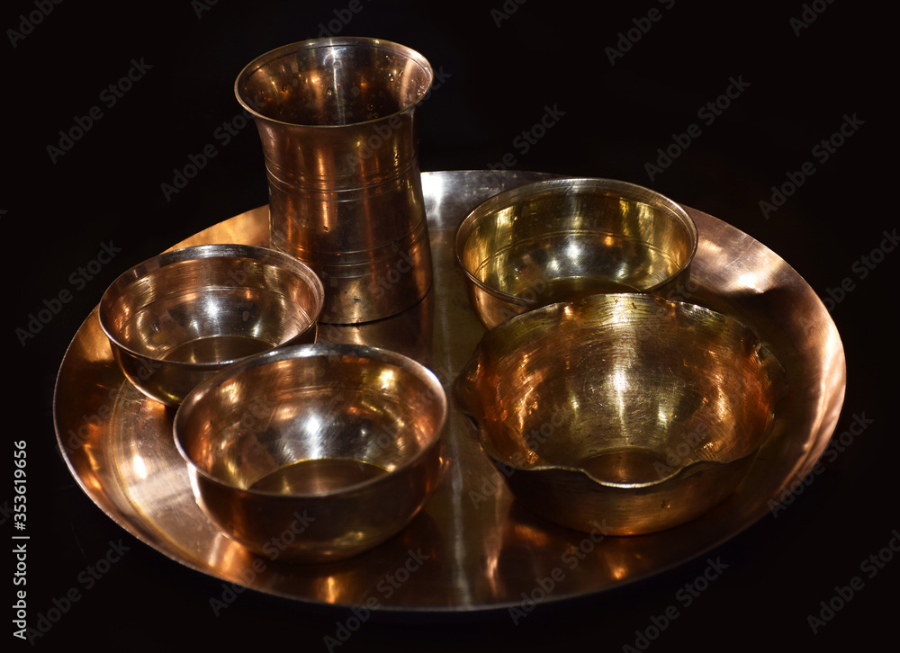Empty Brass Utensils isolated in dark background. Brass is also called as Peetal in Hindi Language. Brass items are mostly used in India during religious festivals