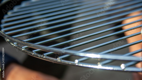 Closeup new metal grill grate. Empty clean grid. Picnic tools. © daily_creativity
