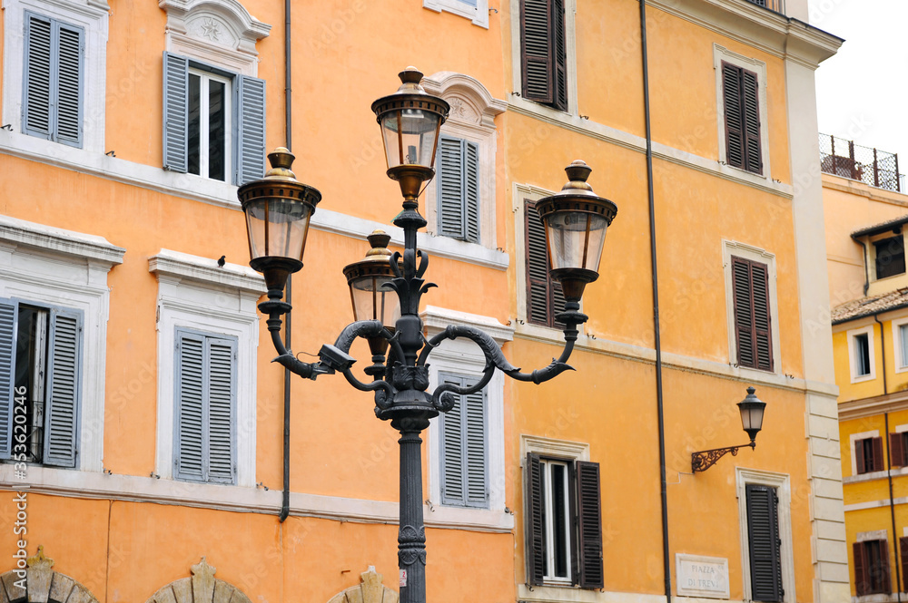 Vintage street light in the Rome square near the ginger building with shutters 