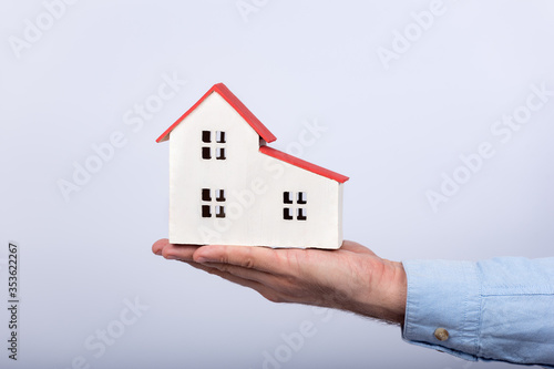 Model of house on palm on white background. Buy own house concept