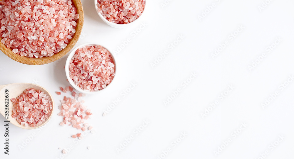 Spa flatlay composition. Sea salt in wooden jar and scattered in spoon on white background. Top view, copyspace, banner. Daily care concept, relax and rest, bath procedure Spa flatlay composition. Sea salt in wooden jar and scattered in spoon on white background. Top view, copyspace, banner. Daily care concept, relax and rest, bath procedure