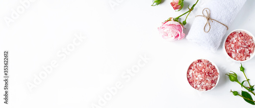 Spa flatlay composition. Sea salt in jar, towel, flower on white background. Top view, copyspace, banner. Daily care concept, relax and rest, bath procedure