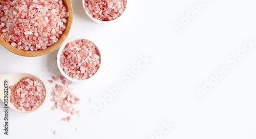Spa flatlay composition. Sea salt in wooden jar and scattered in spoon on white background. Top view, copyspace, banner. Daily care concept, relax and rest, bath procedure