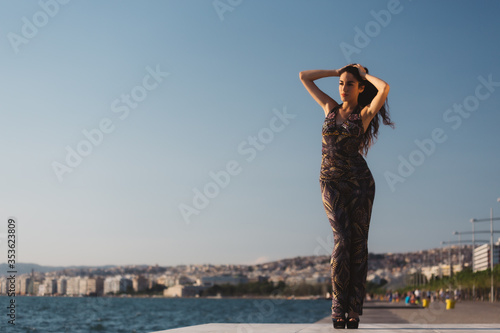 Girl in a long dress on the background of the promenade