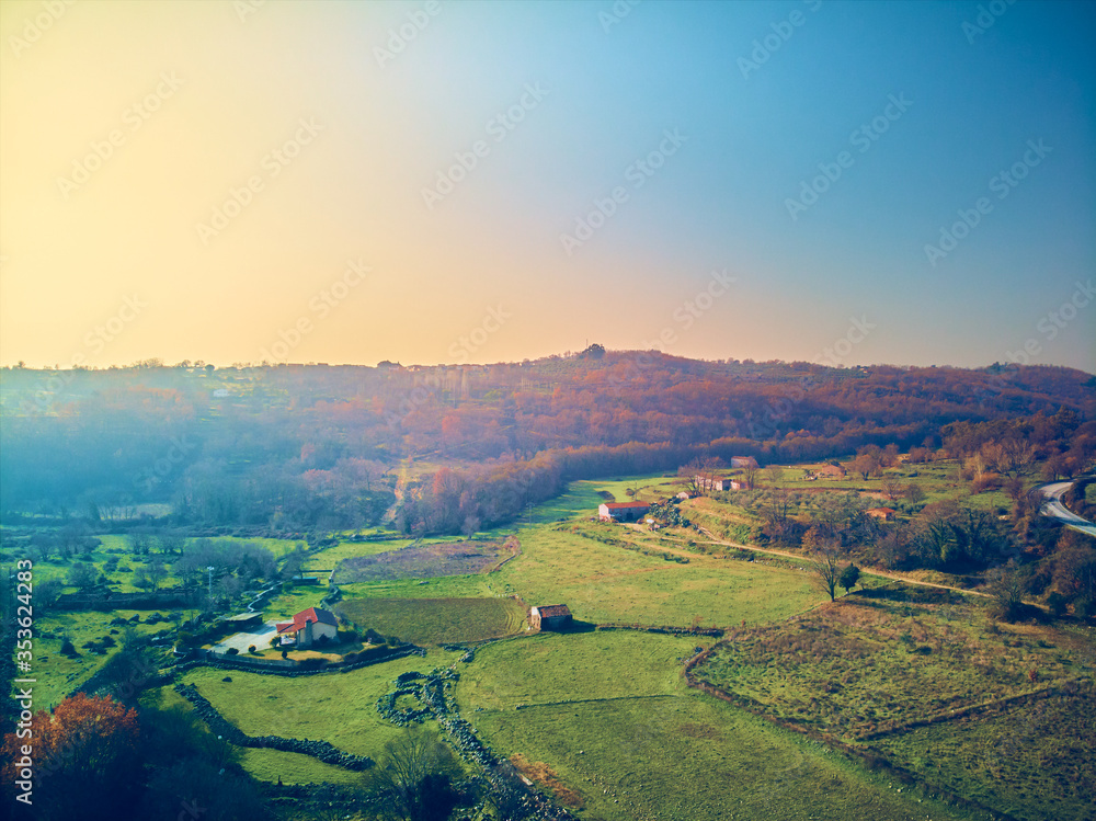 Aerial view of nice landscape of rustic houses and green meadows in autumn
