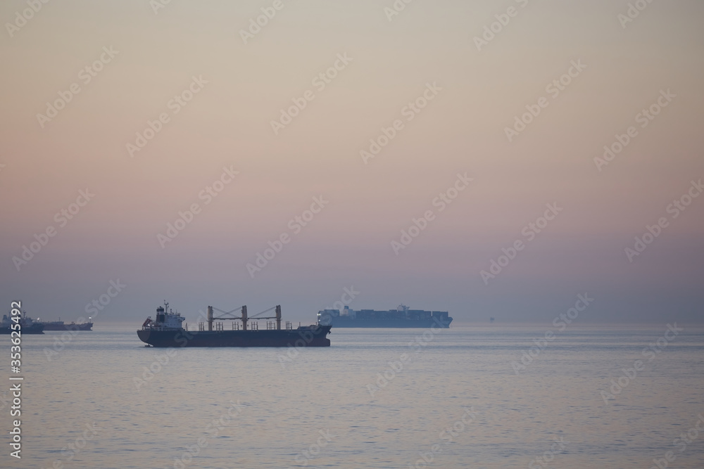 Commercial cargo ships on North Sea crossing in evening dusk light approaching night