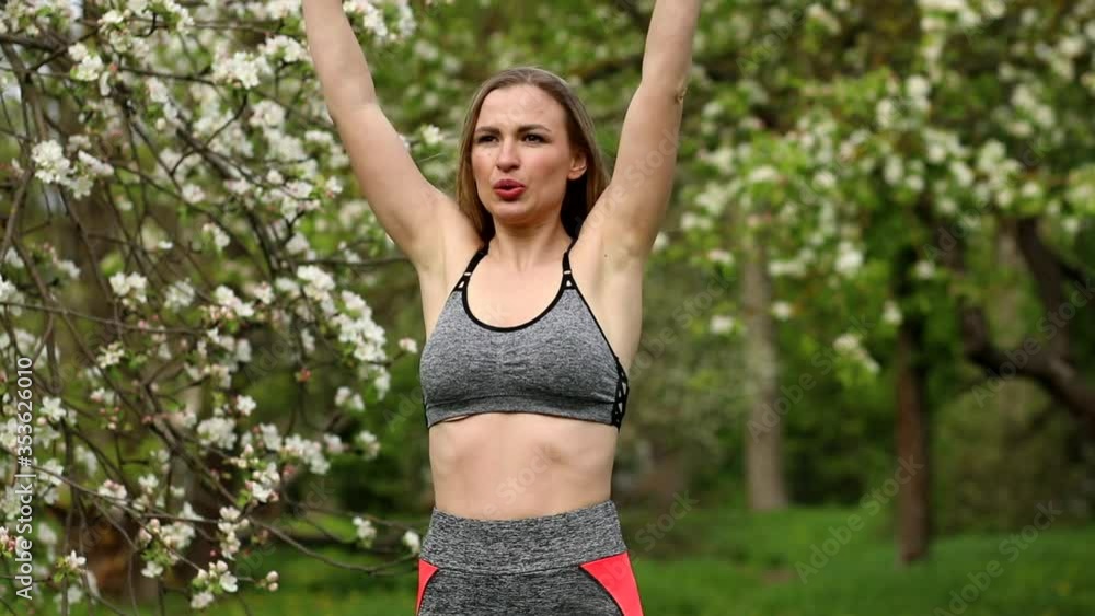 Close up view of athletic woman doing cardio fitness exercises outdoors in the blooming park. Loosing weight programm, concept. Close up view of athletic woman doing cardio fitness exercises outdoors in the blooming park. Loosing weight programm, concept.