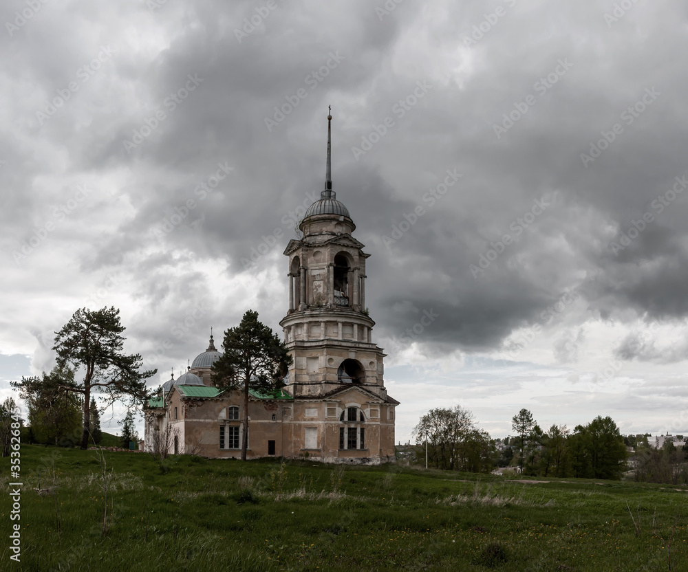 A beautiful old abandoned church stands on a hill near the pine trees