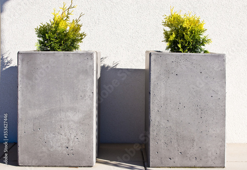 Modern concrete flower pots on front porch of a house