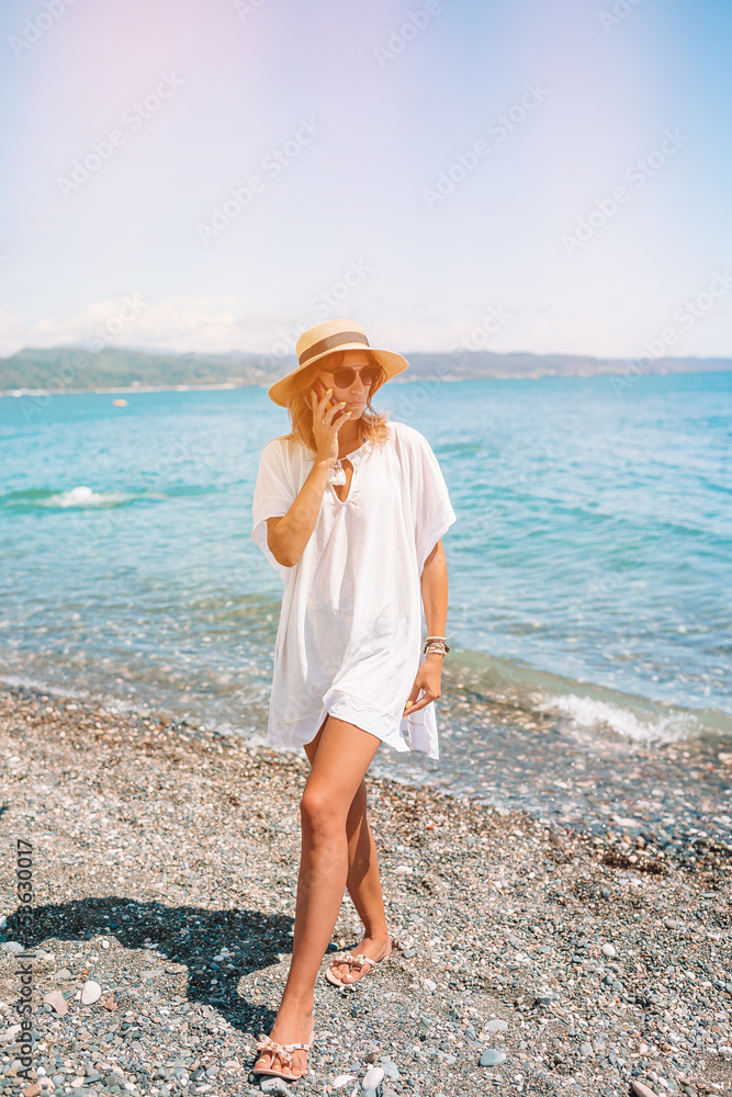 Young fashion woman in green dress on the beach