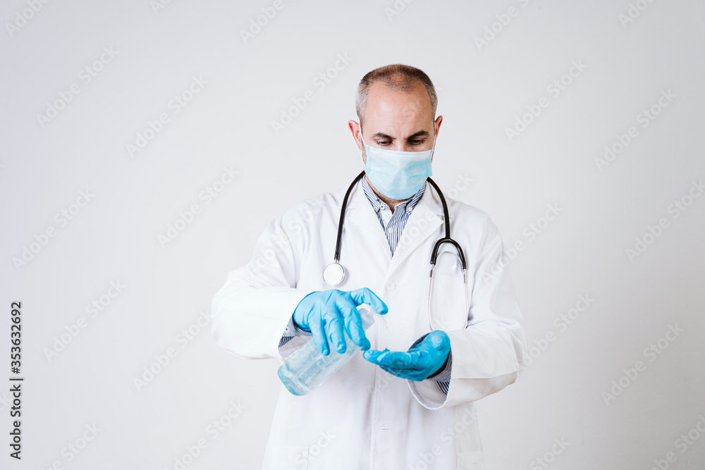 doctor man using alcohol disinfectant gel. using protective mask and gloves during corona virus covid 2019 pandemic. Health care and medical concept doctor man using alcohol disinfectant gel. using protective mask and gloves during corona virus covid 2019 pandemic. Health care and medical concept