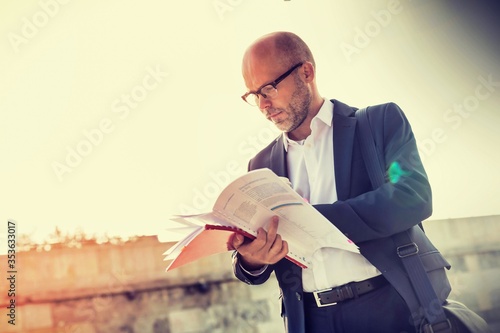 Portrait of businessman reading documents
 photo